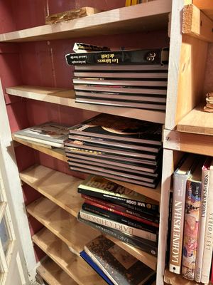 Les livres sont empilés sur une étagère dans une pièce aux murs roses
