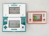 deux consoles de jeux posées l'une à côté de l'autre sur une table