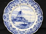 une assiette bleue et blanche sur laquelle est représenté un moulin à vent