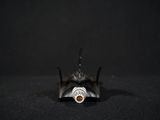 a close up of a bat on a black surface with a black background