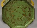 a green vase with a gold decoration on it