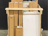 un petit réfrigérateur posé sur une palette à côté d'une pile de cartons