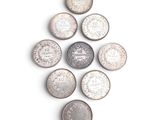 many coins arranged in a circle on a white surface