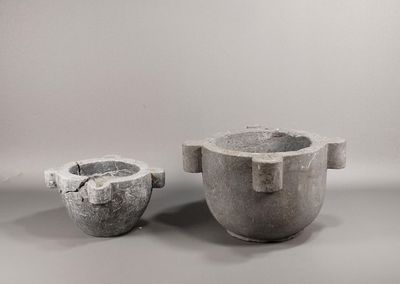 two cement pots sitting next to each other on a table