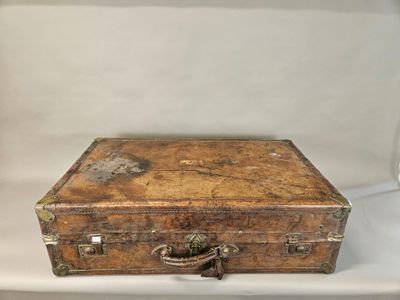 an old wooden suitcase sitting on a white surface