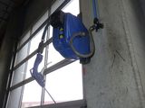 un tuyau bleu fixé au mur près d'une fenêtre
