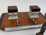 two silver candles on a wooden tray with a figurine on it