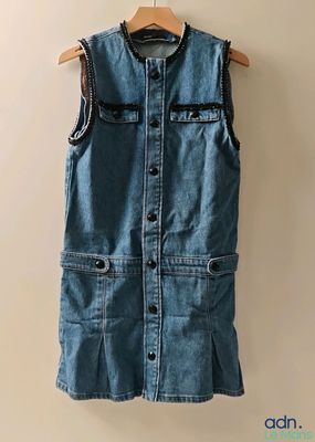 une photo d'un gilet en jean suspendu à un cintre