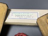 a box with a button and a ball of thread next to it