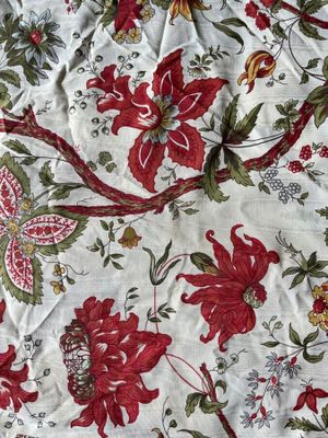 a red and green floral pattern on a white table cloth