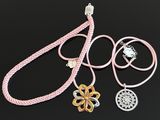 three different colored necklaces on a black surface with a black background