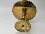 a gold colored candle holder with a small candle on it