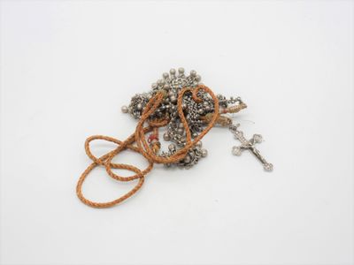 un tas de bijoux en argent et en or posés sur une surface blanche