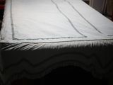 un lit recouvert d'un drap blanc dans une pièce sombre