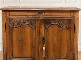 une vieille armoire en bois dans une pièce blanche avec du parquet