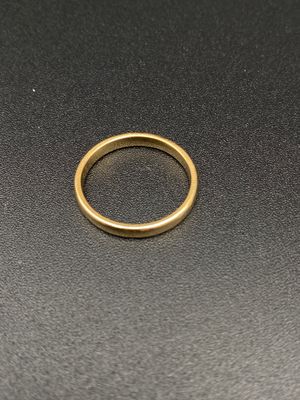 gros plan d'une bague en or sur une surface noire