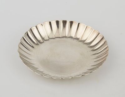 an antique silver plate with a fluted edge