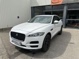 a white jaguar suv parked in front of a building