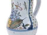 a blue and white vase with a bird and flowers on it
