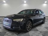 the black audi is parked in a large room with a checkered floor