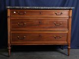 une commode en bois surmontée d'un plateau en marbre