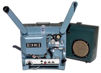 un vieux projecteur de cinéma posé à côté d'un haut-parleur