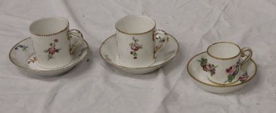 three cups and saucers are sitting on a white table cloth