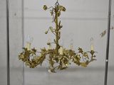 un lustre en or d'où pendent des fleurs et des bougies