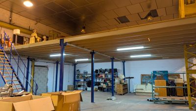 a large room with a ladder and boxes on the floor