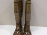 pair of brown rain boots sitting on top of a white table