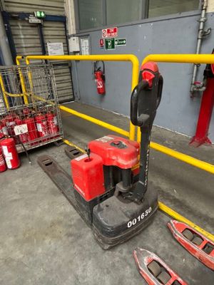 a red and black fork lifter in a warehouse