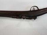 an old rifle with a wooden barrel on a white surface