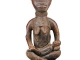 an image of a wooden statue of a woman sitting on her knees