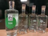 quatre bouteilles de gin sont alignées sur une table en bois