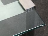 a glass table with a square glass top on the floor