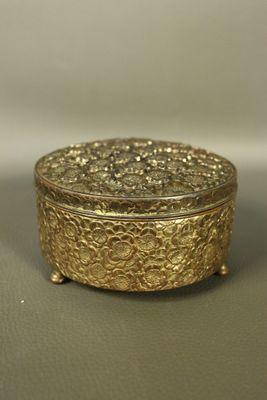 gold plated box on grey surface with white background