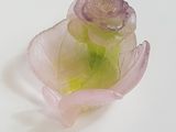 une fleur rose posée sur une surface blanche
