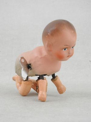 un petit jouet représentant un bébé assis sur une chaise
