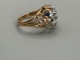 a close up of a gold ring with a black and white diamond
