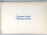 an open book with blue writing on it sitting on top of a table