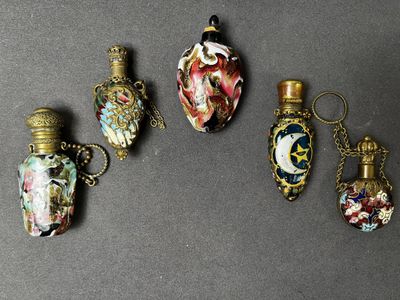 quatre flacons de parfum miniatures sont alignés les uns à côté des autres sur une table