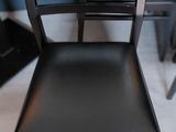 a black chair that is sitting in front of a piano