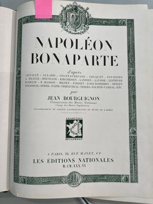 un livre ouvert, sur lequel est collé un autocollant rose, posé sur une table