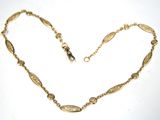 an image of a gold necklace on a white surface