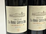 three bottles of red wine are lined up on a table