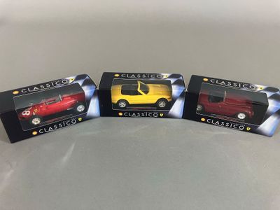 trois cartons contenant des voitures de collection posés sur une table
