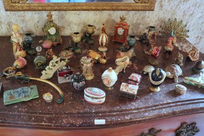 many figurines on a dresser with a mirror in the background