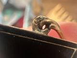someone is holding a ring in their hand with a small bird on it
