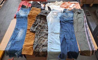 plusieurs paires de jeans disposées sur une table