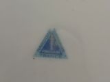 a blue triangle on a white plate on a table